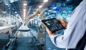 businessperson holding a tablet with charts in high tech manufacturing facility