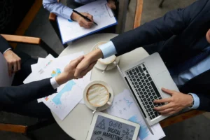 two businessmen shaking hands over a desk
