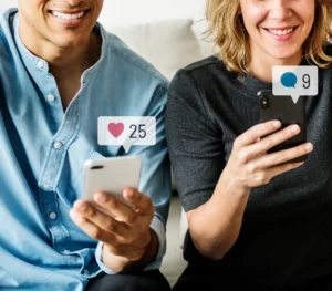 man and woman holding phones smiling with social media icons represented above