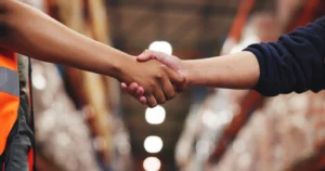 image of two men shaking hands inside a warehouse