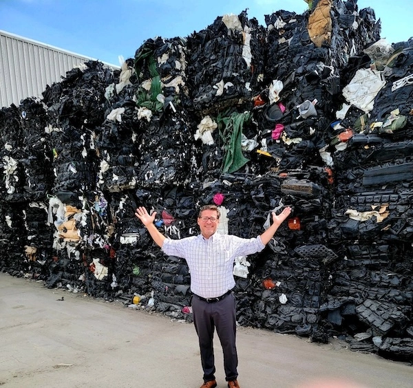 man standing in front of a recycling pile